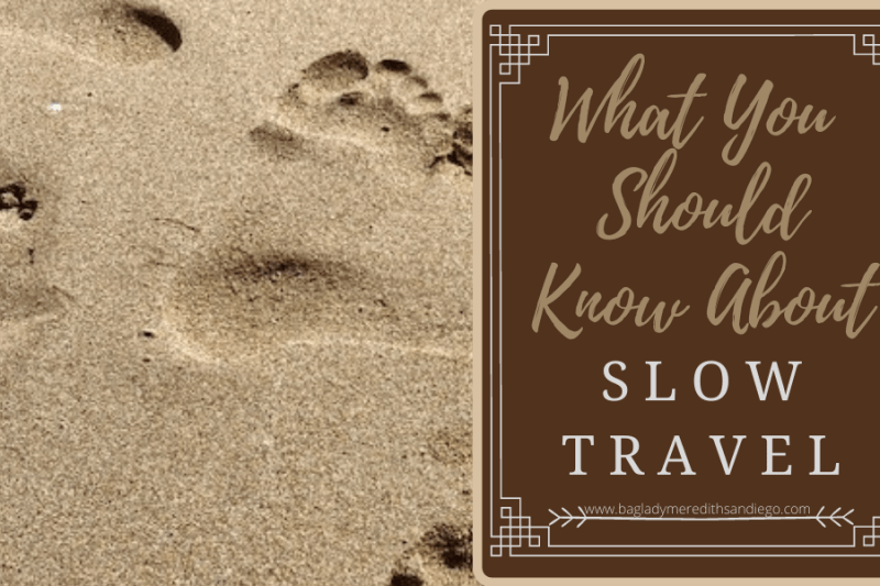 What you should know about slow travel a pin by Meredith with footprints in the sand as a background photo